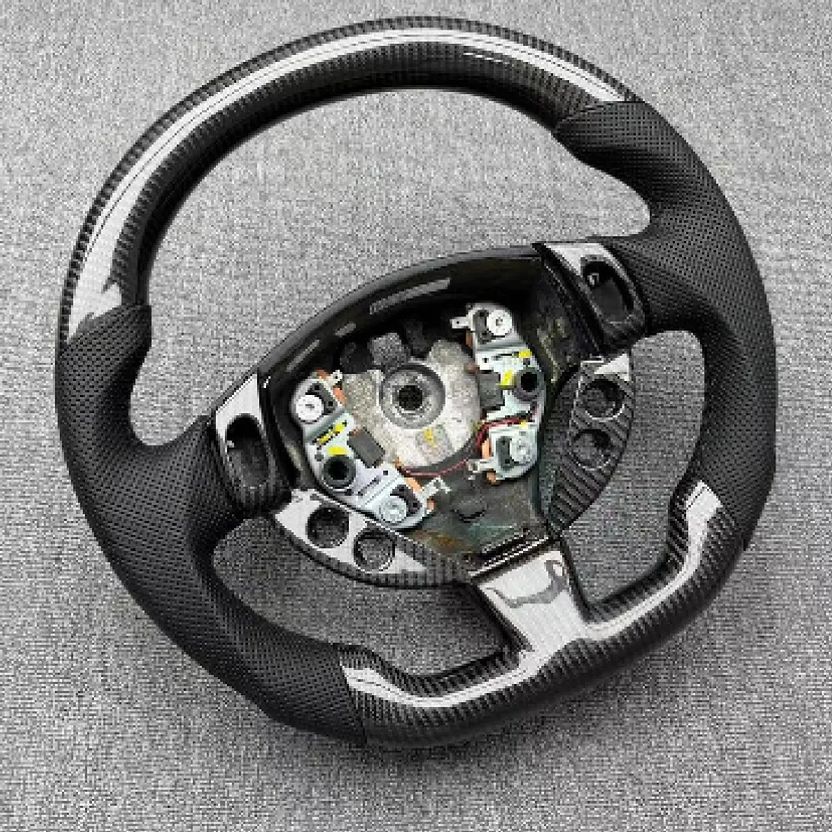 Maserati Levante carbon fiber steering wheel, close view of the grip and button pod area