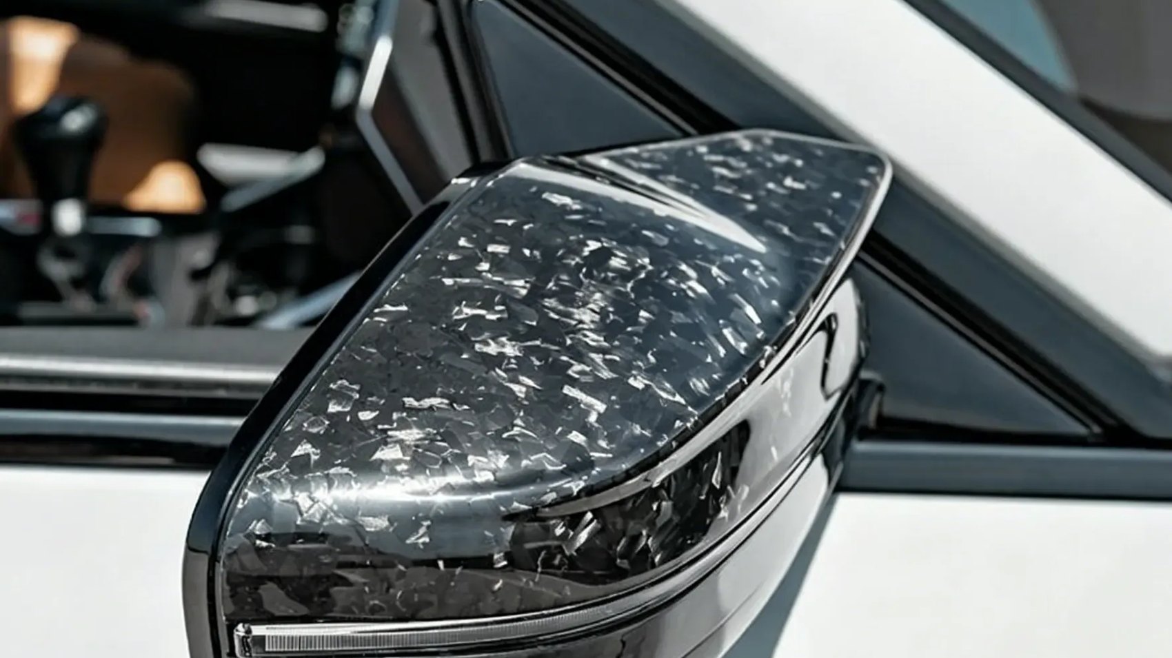 Forged carbon fiber mirror cap fitted to a white car, photographed at the shop