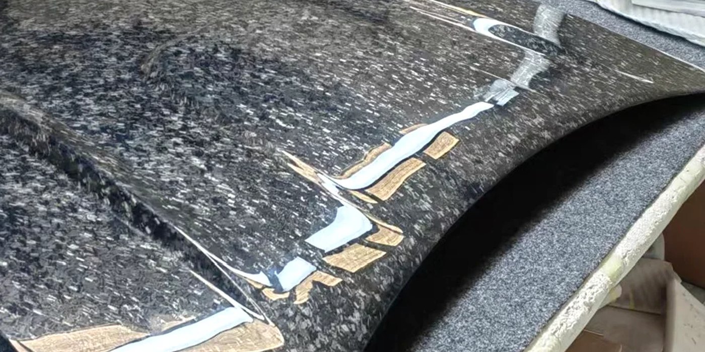 A forged carbon hood on the bench in the workshop